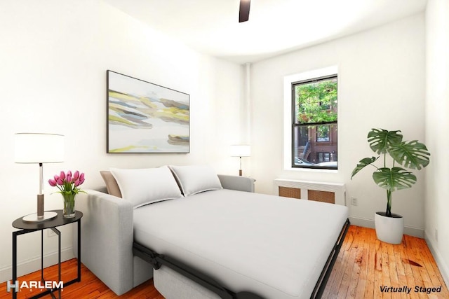 bedroom with radiator, ceiling fan, and light hardwood / wood-style floors