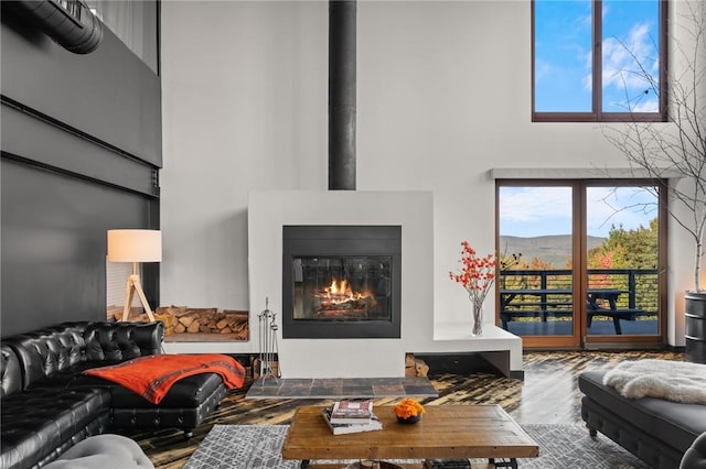 living room featuring a mountain view, wood-type flooring, and a towering ceiling