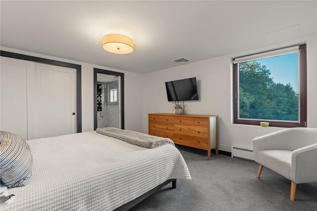 carpeted bedroom featuring a baseboard heating unit