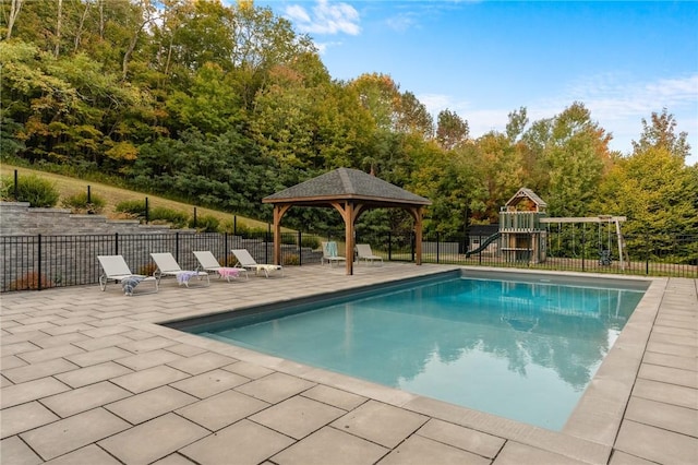 view of swimming pool featuring a playground, a patio area, and a gazebo