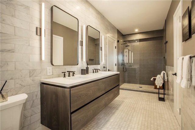 bathroom featuring vanity, tile patterned floors, toilet, tile walls, and a shower with shower door