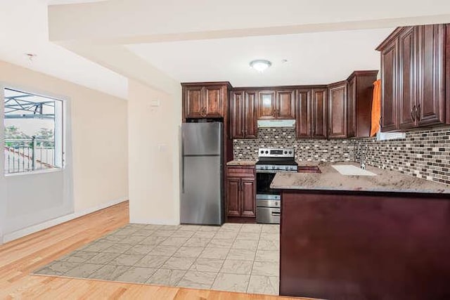 kitchen featuring stone counters, light hardwood / wood-style flooring, decorative backsplash, dark brown cabinets, and appliances with stainless steel finishes