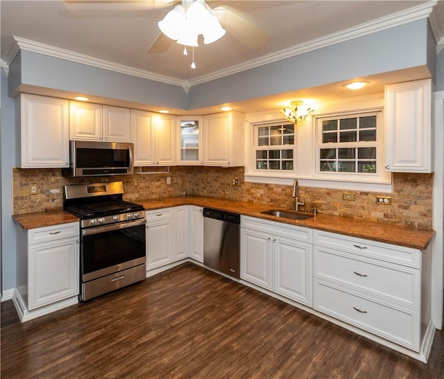 kitchen featuring decorative backsplash, appliances with stainless steel finishes, dark wood-type flooring, sink, and white cabinetry