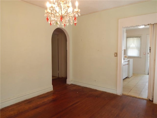 unfurnished room featuring ornamental molding, hardwood / wood-style flooring, and a notable chandelier