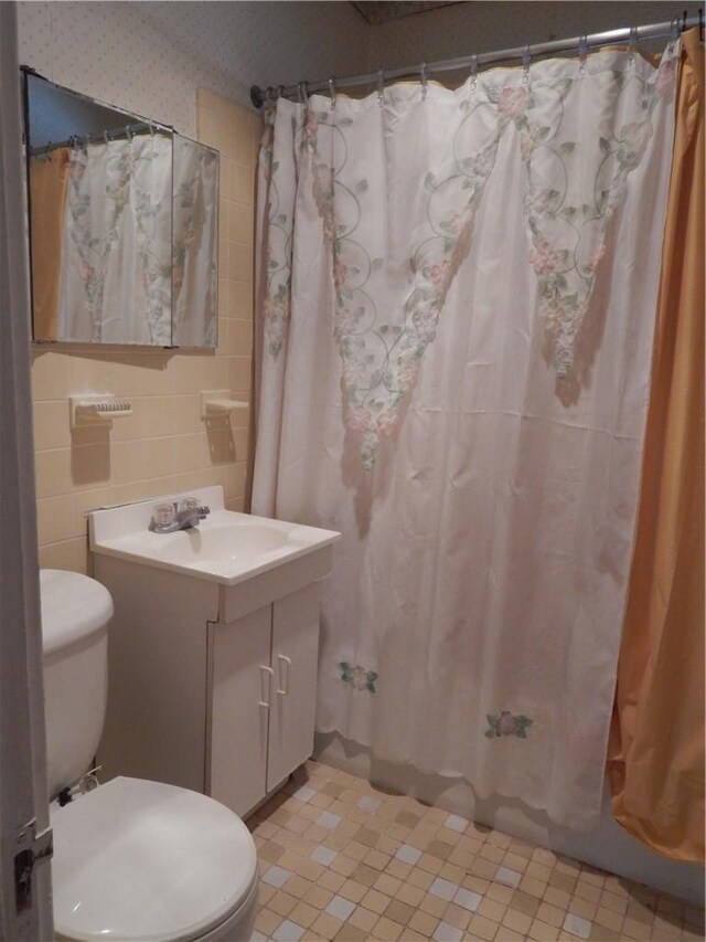 bathroom with toilet and tile walls