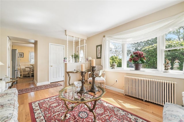 sitting room with radiator heating unit and light hardwood / wood-style floors