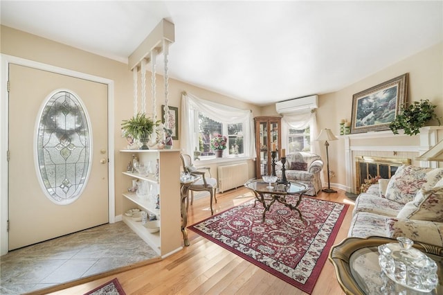 interior space with a wall mounted air conditioner, light hardwood / wood-style flooring, plenty of natural light, and radiator