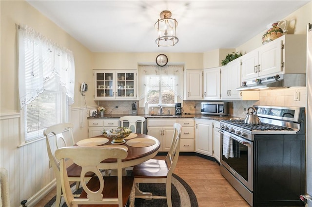 kitchen featuring appliances with stainless steel finishes, light wood-type flooring, white cabinetry, and sink