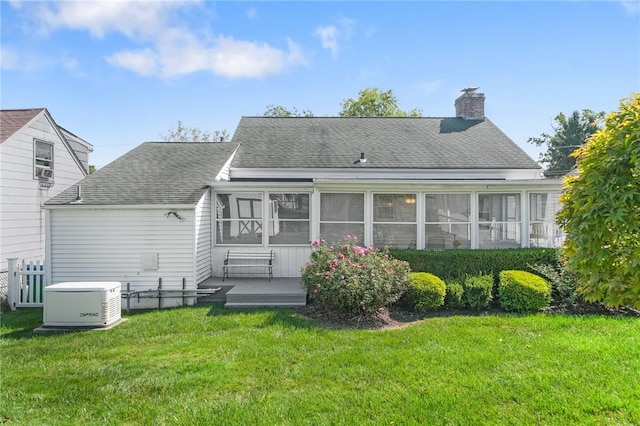 back of house with a yard and a sunroom