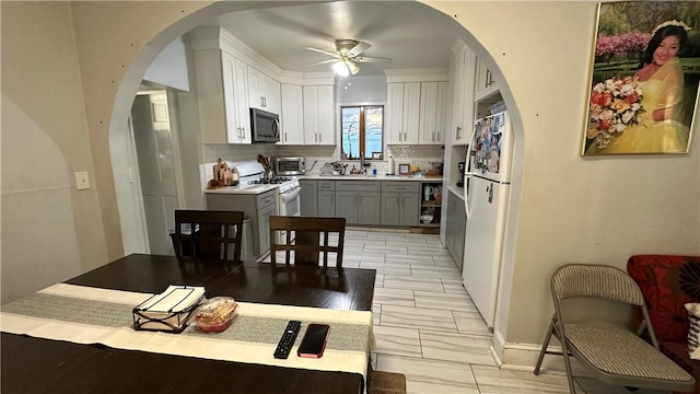 kitchen with white appliances, ceiling fan, gray cabinets, tasteful backsplash, and white cabinetry