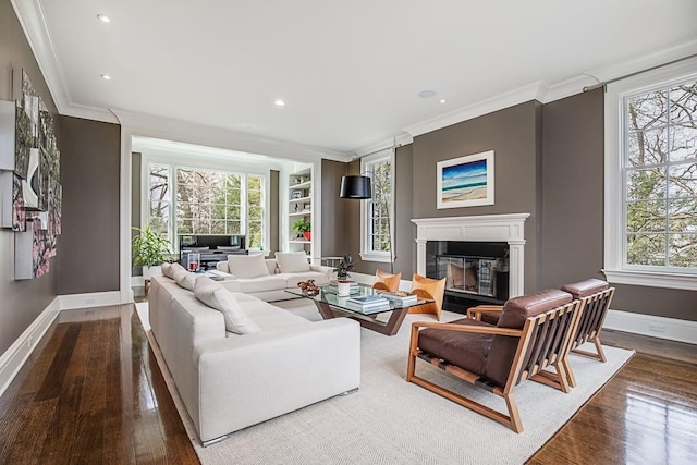 living room featuring hardwood / wood-style flooring, ornamental molding, and a wealth of natural light