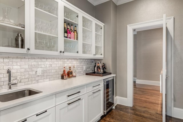 interior space with dark hardwood / wood-style floors, white cabinetry, sink, beverage cooler, and decorative backsplash