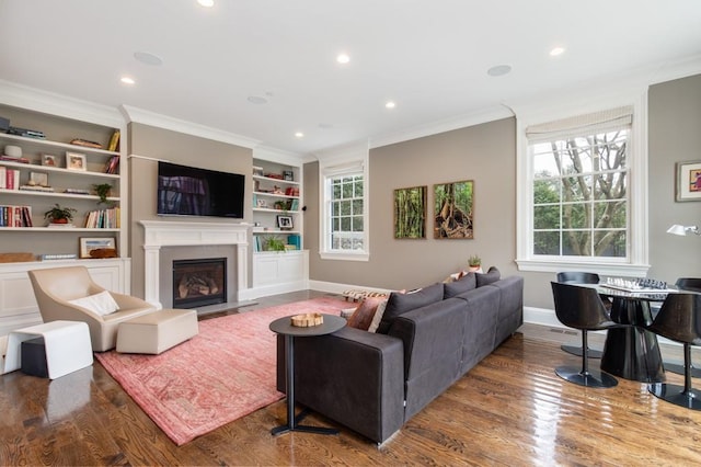 living room with built in features, dark wood-type flooring, and ornamental molding