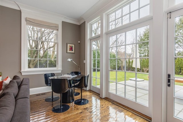 doorway to outside featuring ornamental molding, light hardwood / wood-style flooring, and plenty of natural light