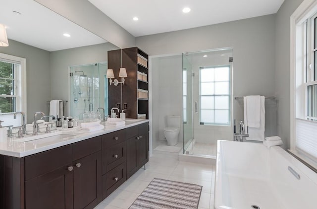 bathroom featuring tile patterned floors, vanity, toilet, and a shower with shower door