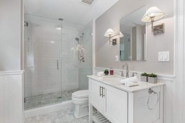 bathroom featuring vanity, walk in shower, and toilet