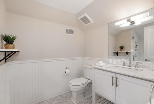 bathroom with vanity, a shower with shower door, and toilet