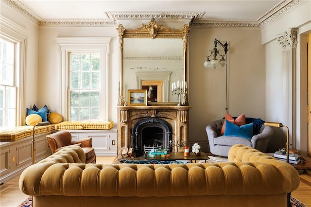 living area with light hardwood / wood-style flooring, a wealth of natural light, and ornamental molding