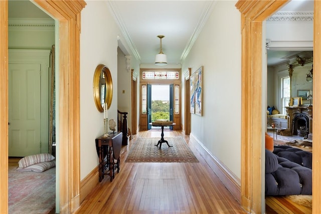 hall with wood-type flooring and ornamental molding