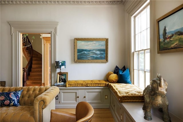 sitting room with a healthy amount of sunlight, light wood-type flooring, and crown molding