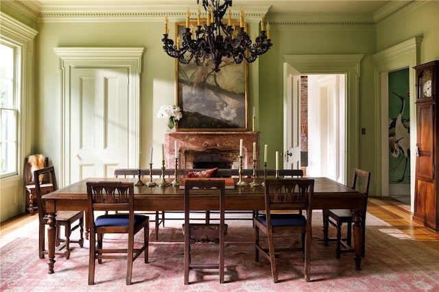 dining space with hardwood / wood-style flooring, a notable chandelier, and crown molding