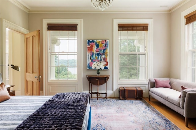 bedroom featuring hardwood / wood-style floors, ornamental molding, and an inviting chandelier