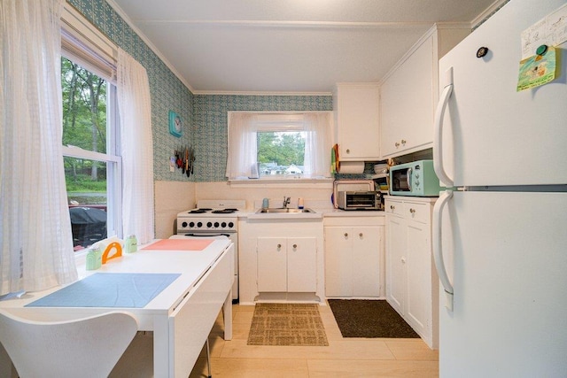 kitchen featuring ornamental molding, white appliances, sink, light tile patterned floors, and white cabinets