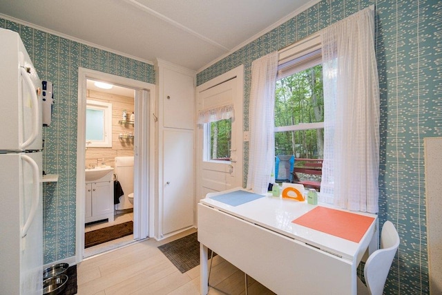 interior space with toilet, vanity, ornamental molding, and hardwood / wood-style flooring