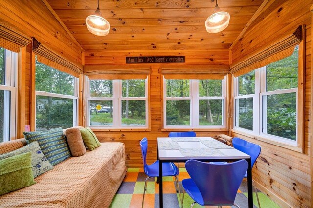 sunroom / solarium featuring vaulted ceiling, a wealth of natural light, and wooden ceiling