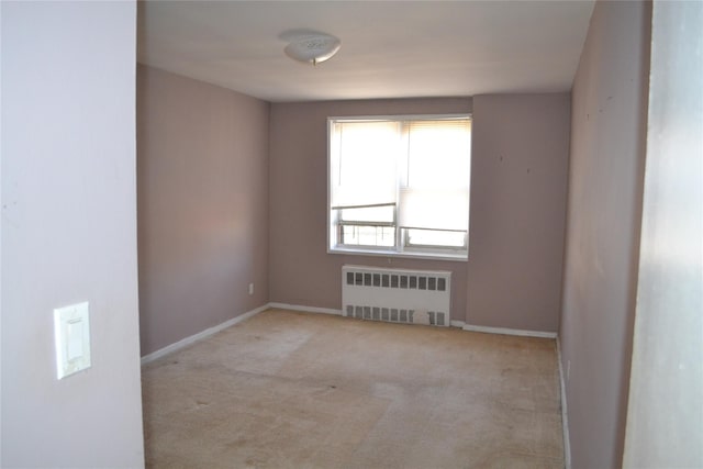 carpeted spare room featuring radiator