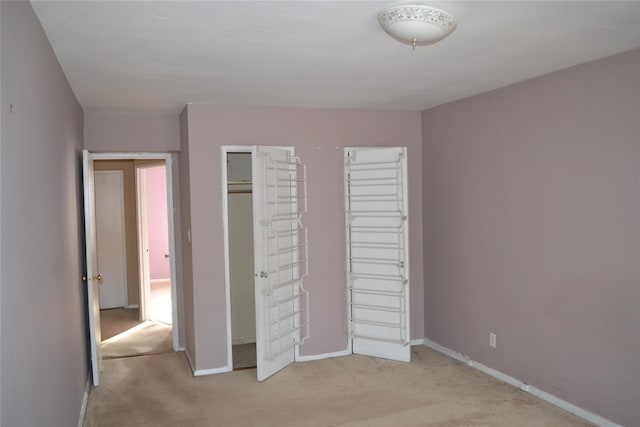 unfurnished bedroom featuring light colored carpet and a closet