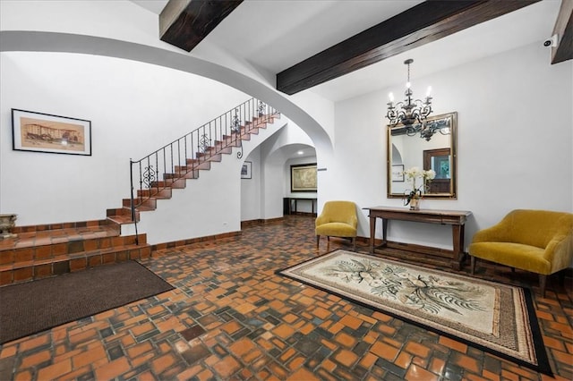 foyer entrance with beam ceiling and a chandelier