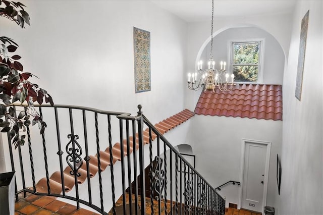 staircase with a notable chandelier