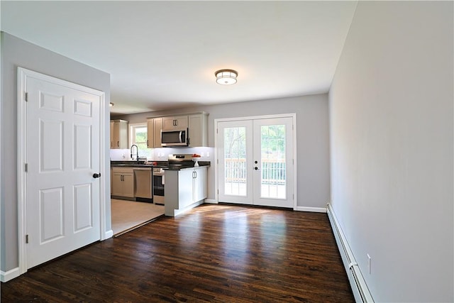 kitchen with french doors, sink, stainless steel appliances, baseboard heating, and dark hardwood / wood-style floors