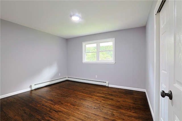 spare room with baseboard heating and dark wood-type flooring