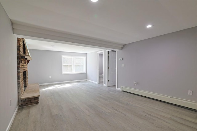 unfurnished living room featuring light hardwood / wood-style floors, a fireplace, and a baseboard radiator