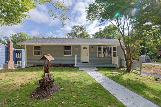 view of front of house featuring a storage unit and a front yard