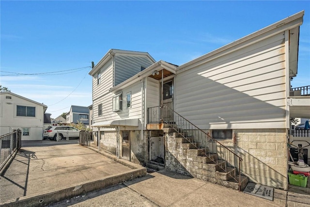 view of home's exterior with driveway and fence