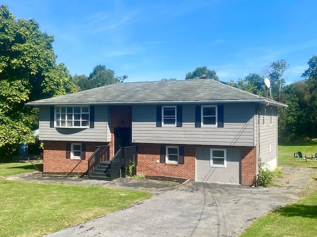 raised ranch with a garage and a front yard