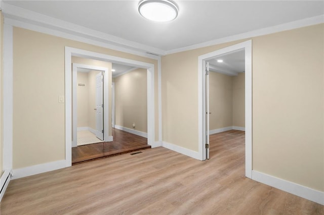 unfurnished room featuring light hardwood / wood-style flooring, baseboard heating, and ornamental molding