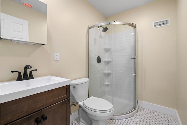 bathroom featuring tile patterned flooring, vanity, toilet, and walk in shower