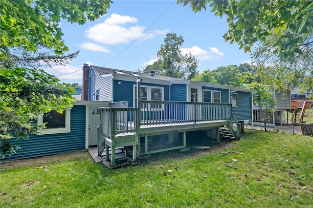 rear view of property featuring a yard and a wooden deck