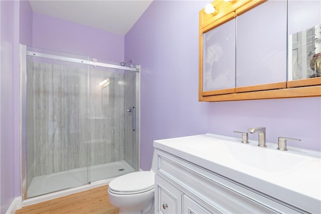 bathroom featuring hardwood / wood-style floors, vanity, toilet, and a shower with door