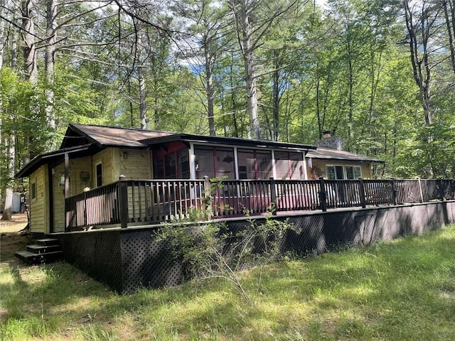 back of property featuring a sunroom and a deck