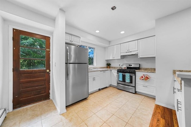 kitchen with plenty of natural light, light stone counters, white cabinetry, and appliances with stainless steel finishes