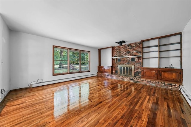 unfurnished living room with a brick fireplace, a baseboard radiator, and light hardwood / wood-style flooring