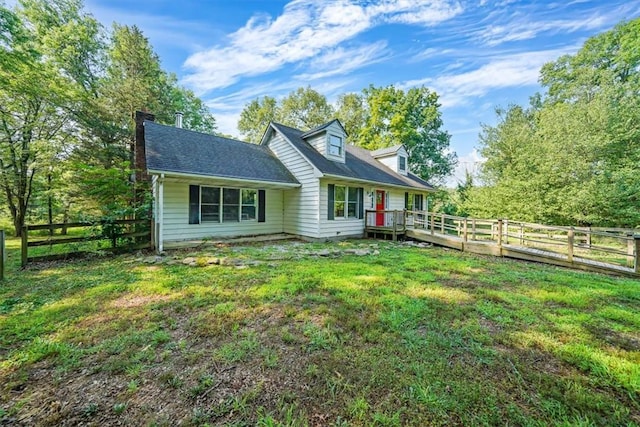 back of property featuring a lawn and a deck