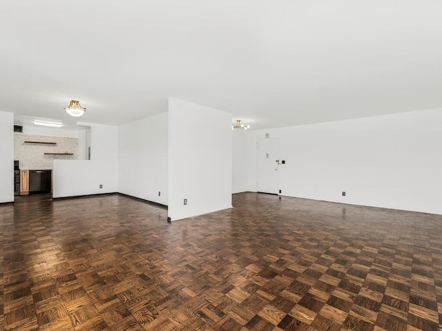 unfurnished living room with dark parquet floors