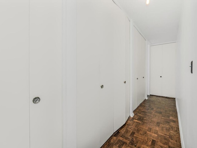 corridor featuring dark parquet flooring