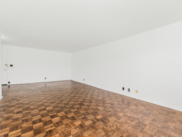 spare room featuring dark parquet floors